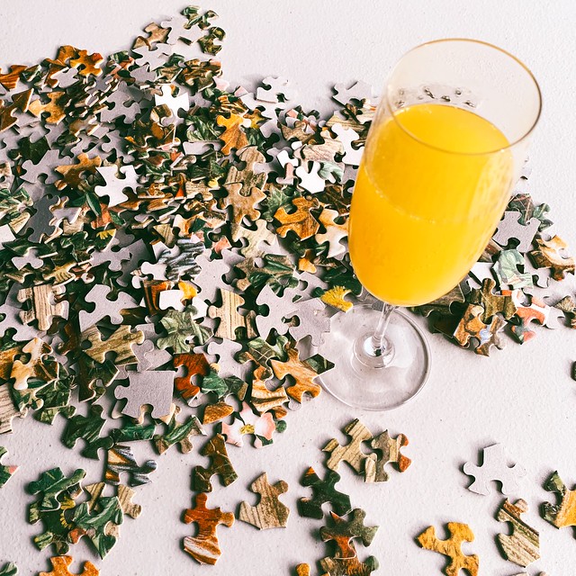 Pile of puzzle pieces and a glass of mimosa