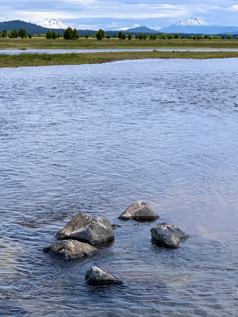 Davis Lake in Oregon with mountains in the background and small rocks in the foreground