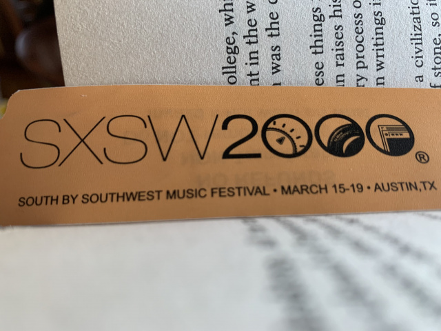 photo of an orange south by southwest music festival wristband in the spine of a book